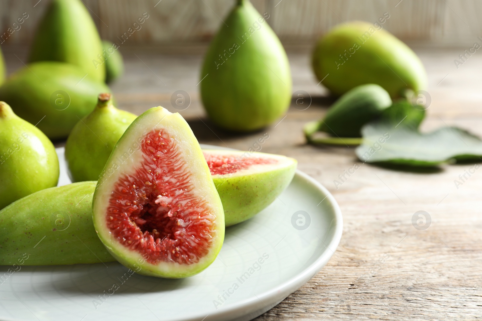 Photo of Plate with fresh ripe figs on table. Tropical fruit