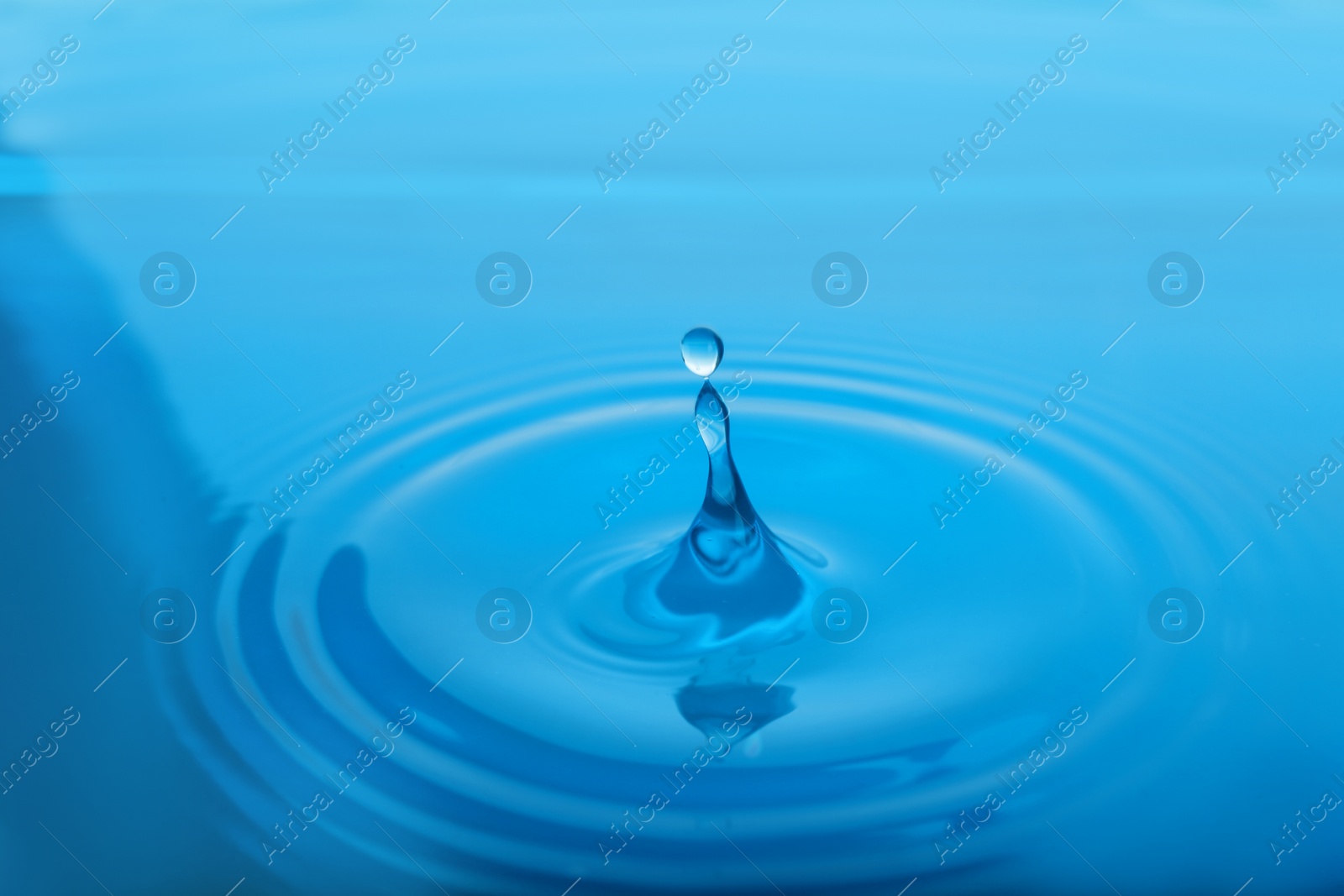 Photo of Splash of blue water with drop as background, closeup