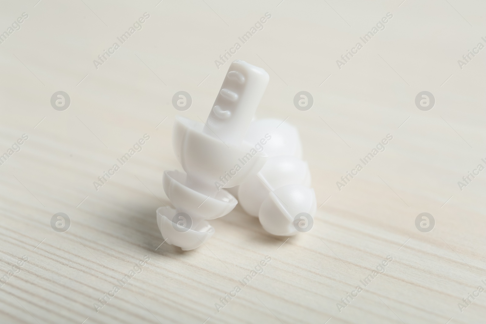 Photo of Pair of ear plugs on white wooden background, closeup