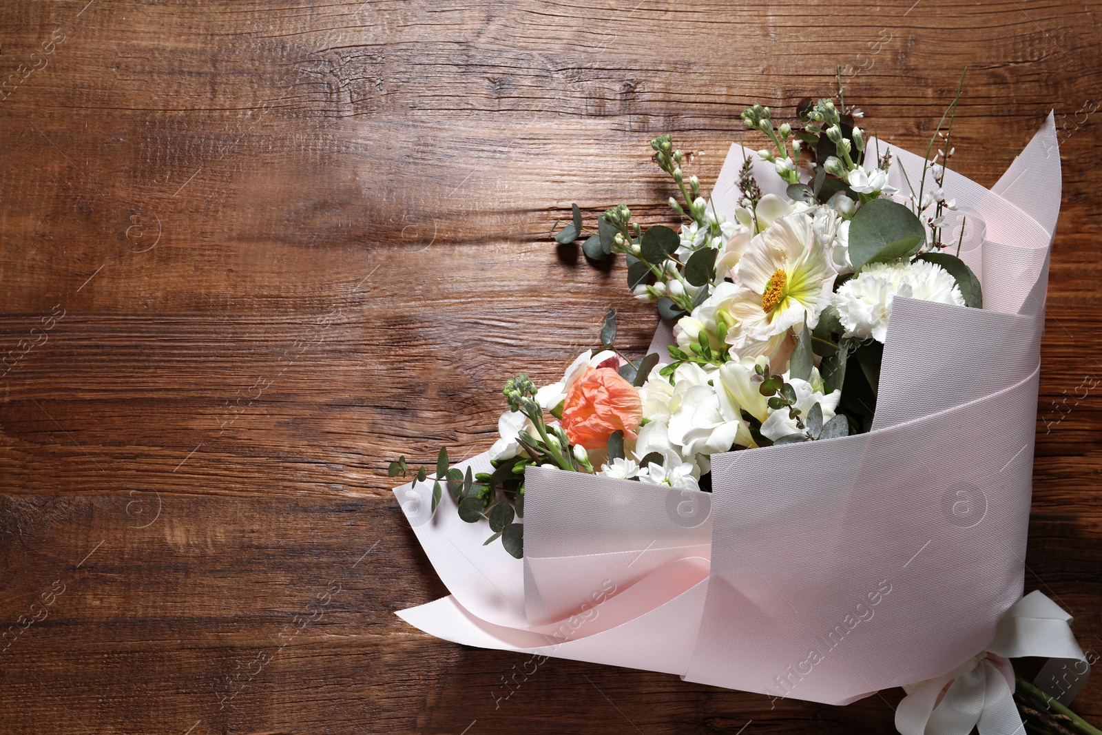 Photo of Bouquet of beautiful flowers on wooden table, top view. Space for text