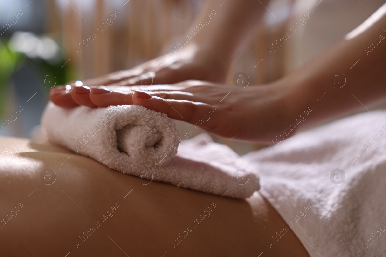 Photo of Spa therapy. Beautiful young woman lying on table during hot towel massage in salon, closeup