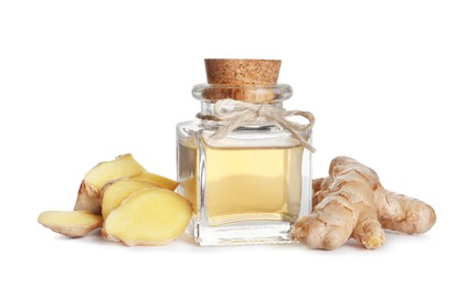 Glass bottle of essential oil and ginger root on white background