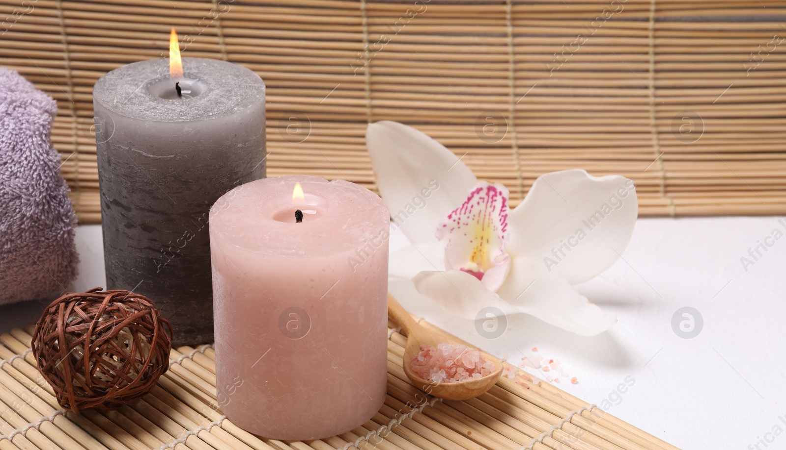 Photo of Composition with spa products, beautiful flower and burning candle on white table