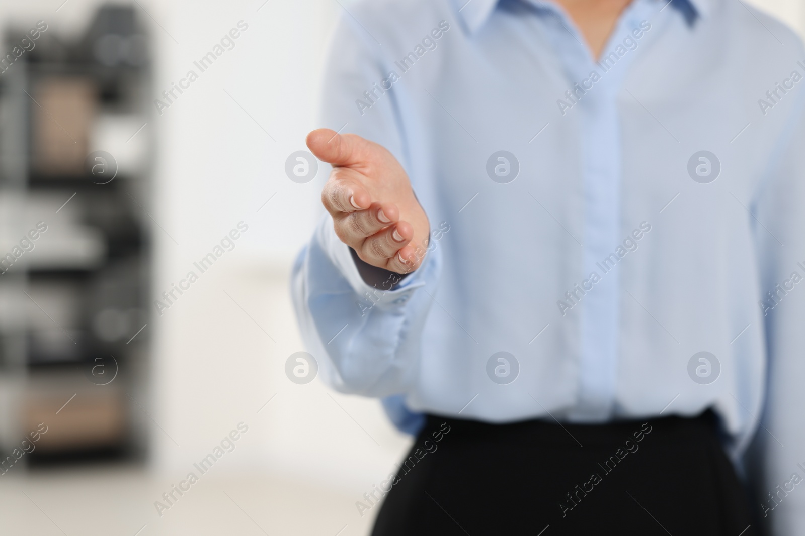 Photo of Woman welcoming and offering handshake indoors, closeup. Space for text