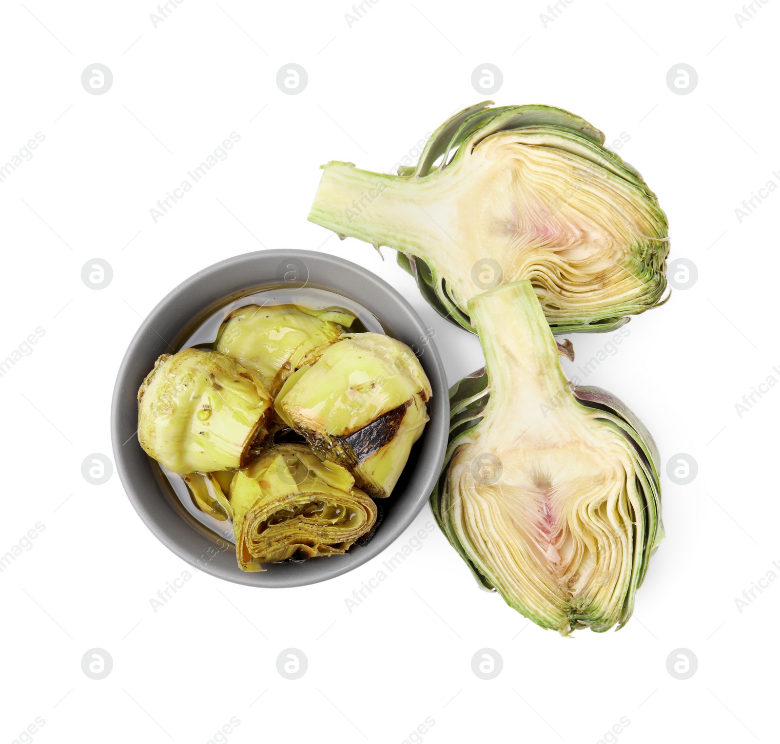 Photo of Bowl with delicious artichokes pickled in olive oil and fresh vegetables on white background, top view
