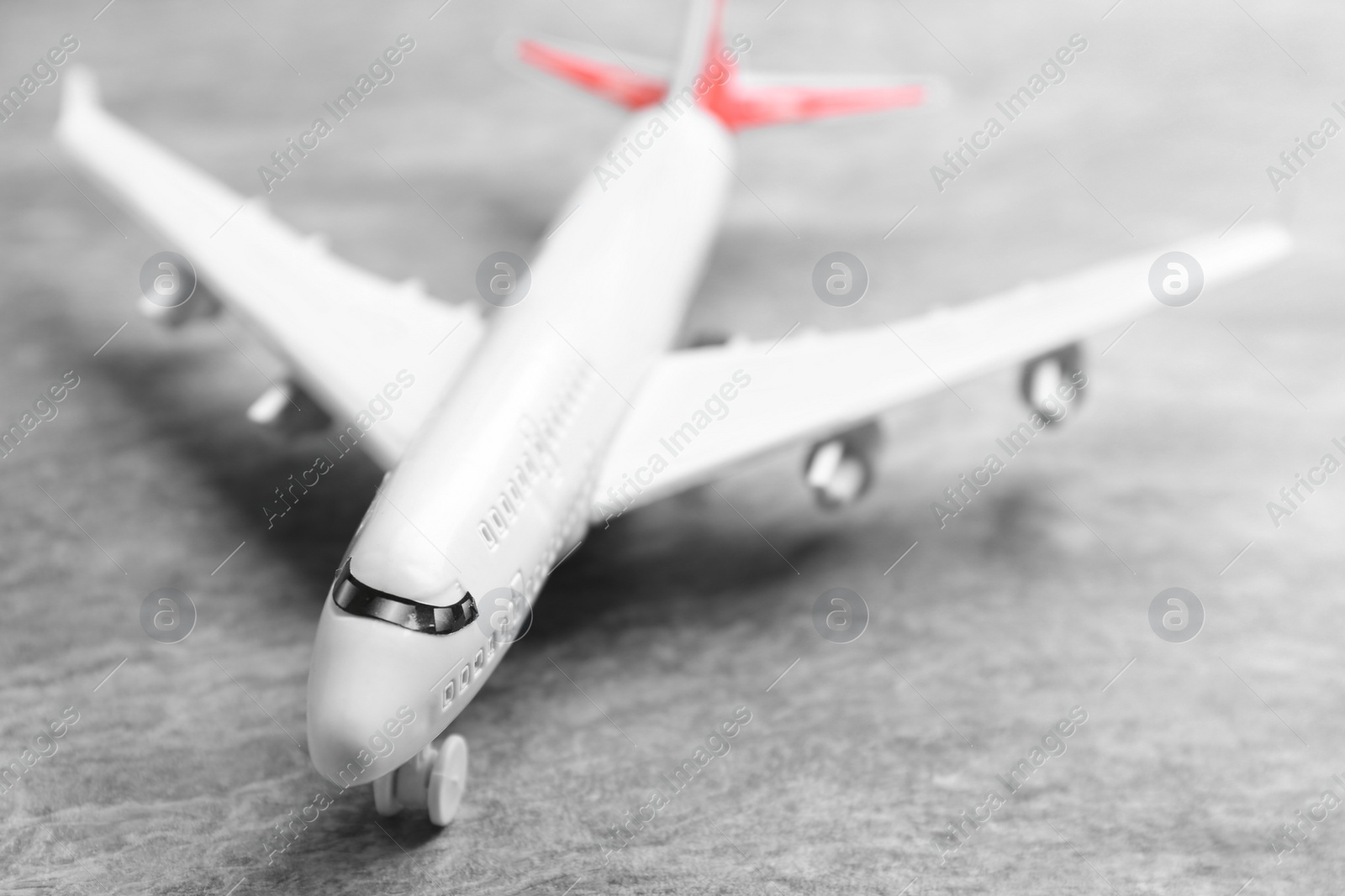 Photo of Toy airplane on grey stone background, closeup