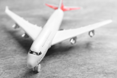 Toy airplane on grey stone background, closeup