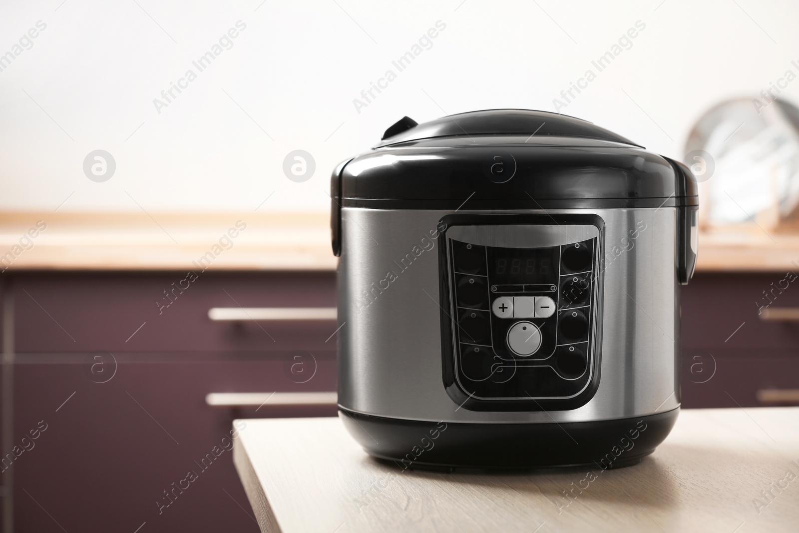 Photo of Modern multi cooker on table in kitchen. Space for text