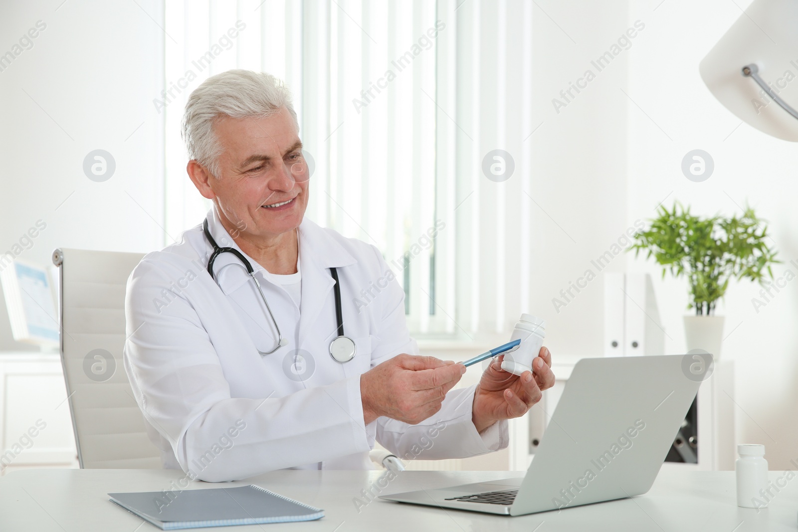 Photo of Doctor consulting patient using video chat on laptop in clinic