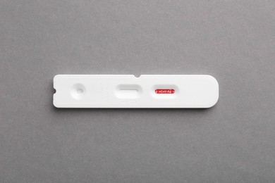 Photo of Disposable Covid-19 express test on grey background, top view