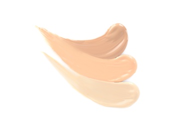 Samples of different foundation shades on white background, top view