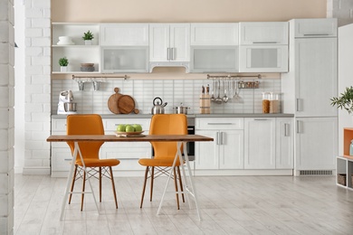 Stylish kitchen interior with dining table and chairs