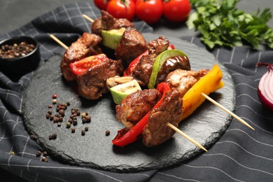 Delicious shish kebabs with vegetables and spices on table