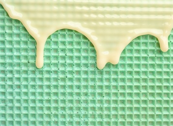 Photo of Hot white chocolate on wafer, closeup. Crispy food