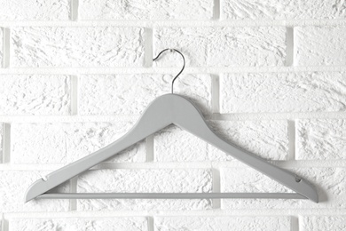 Photo of Empty clothes hanger on brick wall. Wardrobe accessory