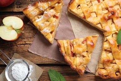 Photo of Traditional apple pie and ingredients on wooden table, flat lay