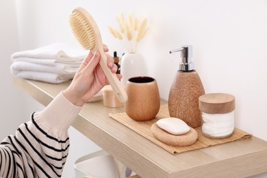 Photo of Bath accessories. Woman with brush indoors, closeup