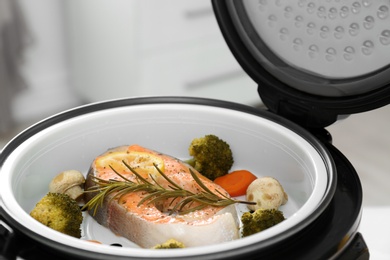 Photo of Salmon steak with garnish in multi cooker, closeup