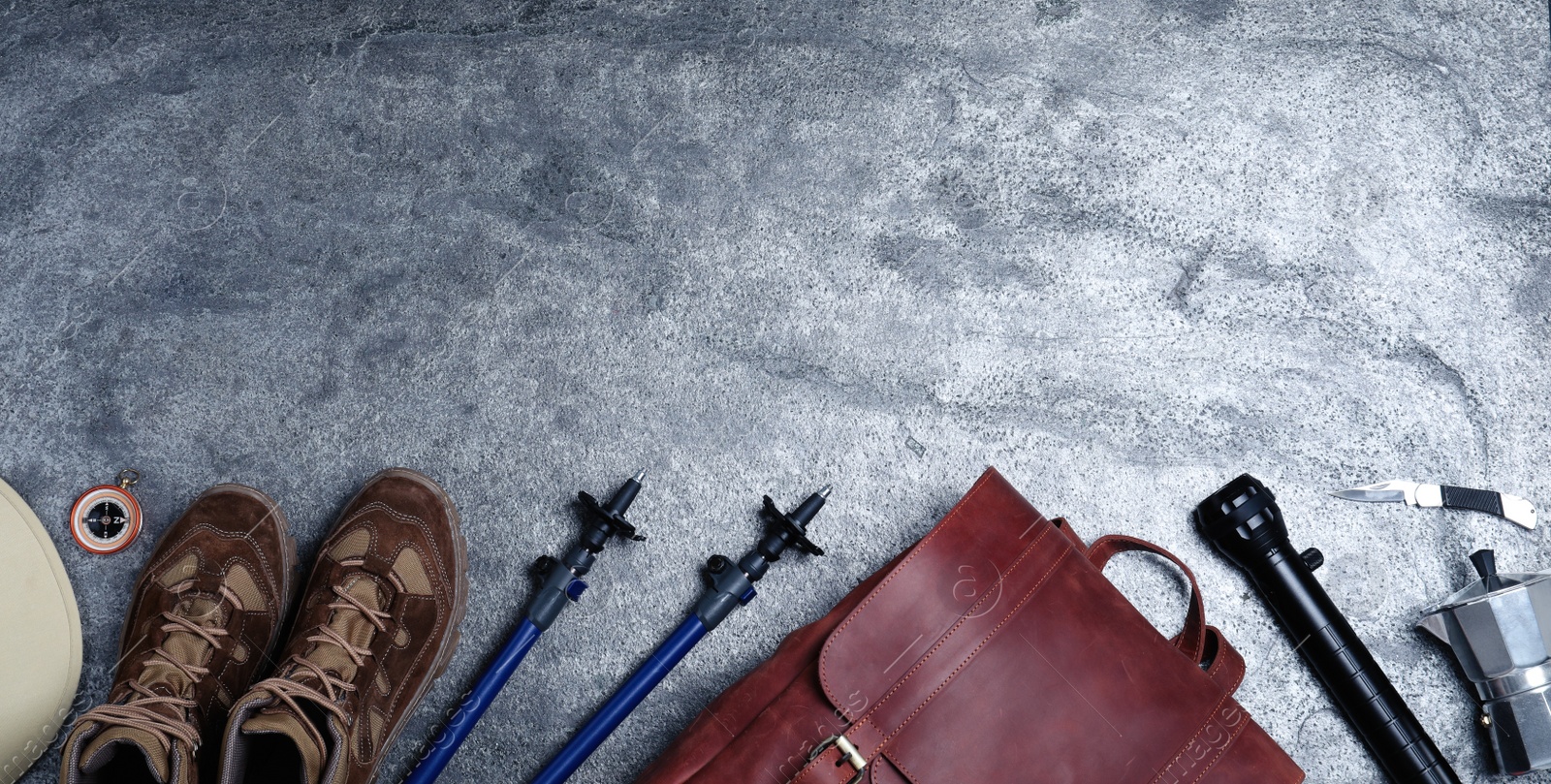 Photo of Flat lay composition with leather tourist backpack and different camping equipment on grey background, space for text