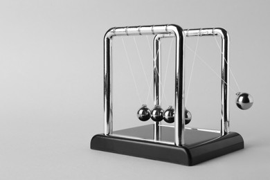 Newton's cradle on light background, space for text. Physics law of energy conservation