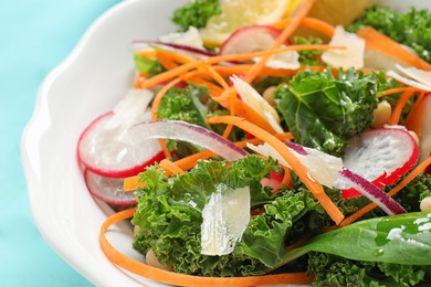 Photo of Tasty fresh kale salad on light blue table, closeup