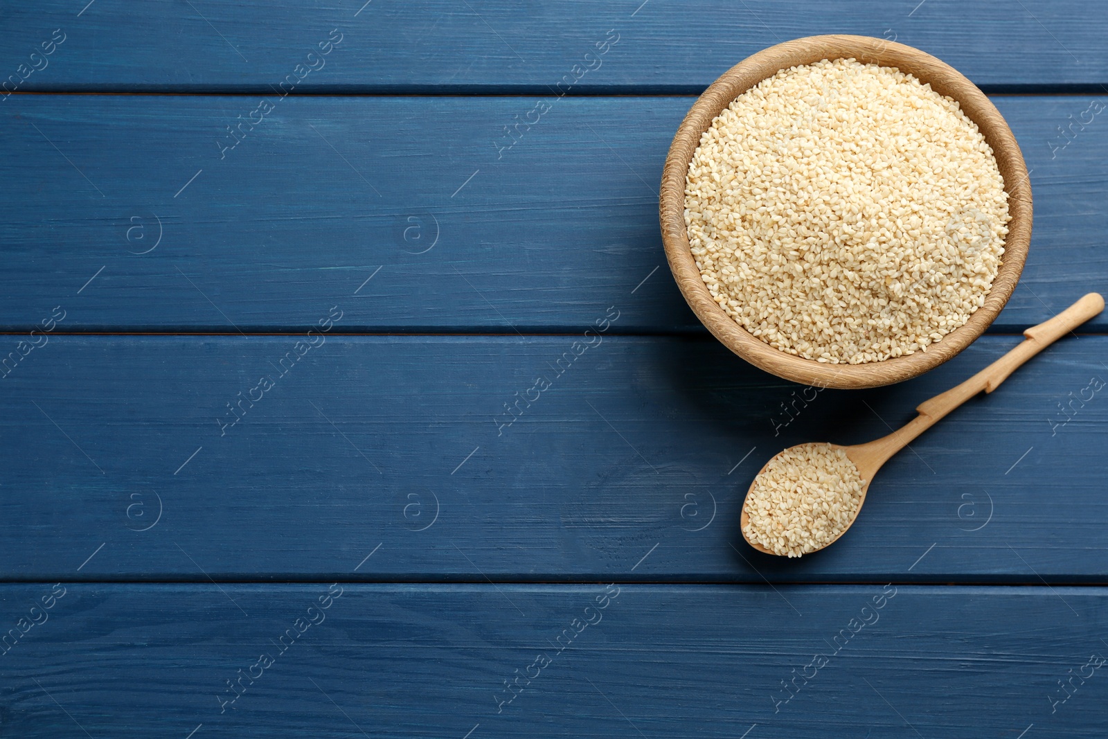 Photo of Sesame seeds on blue wooden table, flat lay. Space for text