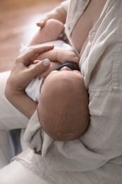 Photo of Mother holding her sleeping baby indoors, closeup