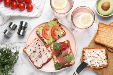 Different tasty sandwiches served on white marble table, flat lay