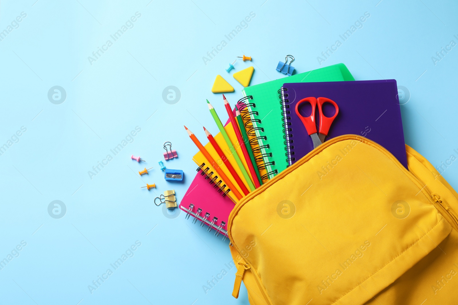 Photo of Flat lay composition with backpack, school stationery and space for text on color background