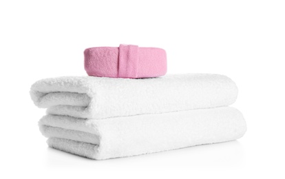 Photo of Stack of clean soft towels and sponge on white background