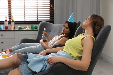 Young women sleeping in messy room after party