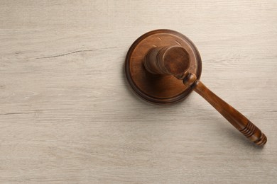 Photo of Wooden gavel on light table, top view. Space for text