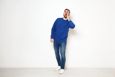 Photo of Full length portrait of emotional man against white wall