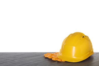 Photo of Hard hat and gloves on wooden table against white background. Safety equipment