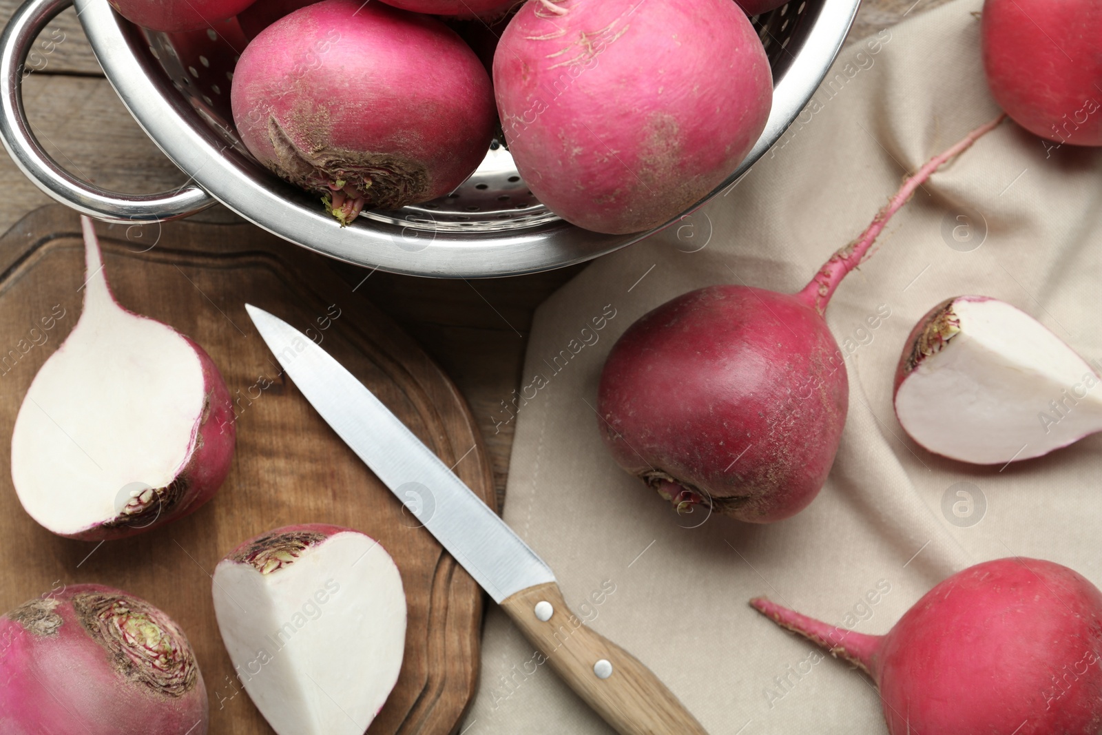 Photo of Red turnips and knife on wooden table, flat lay