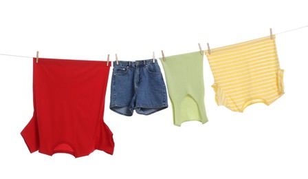 Different clothes drying on laundry line against white background