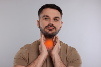 Image of Endocrine system. Man doing thyroid self examination on light grey background
