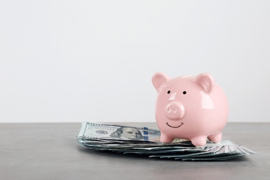 Piggy bank with dollar banknotes on table against white background. Space for text