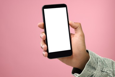 Photo of Man holding smartphone with blank screen on pink background, closeup. Mockup for design