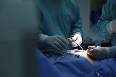 Medical team performing surgery in operating room, closeup