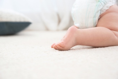 Cute little baby crawling on carpet indoors, closeup with space for text