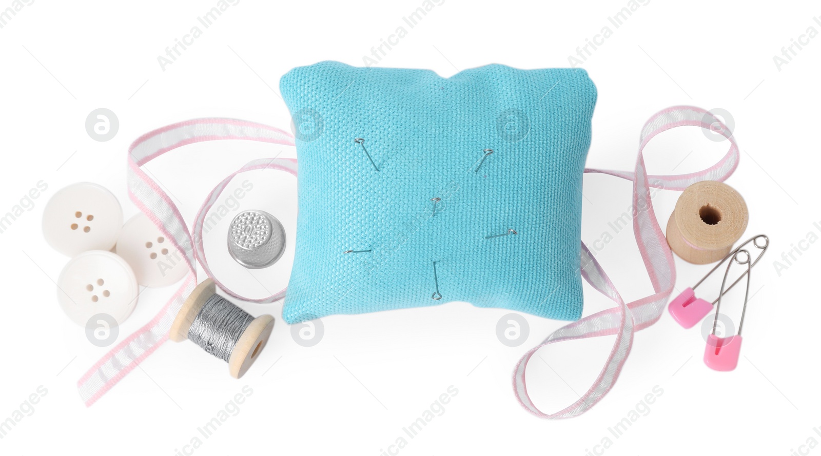 Photo of Pincushion, needles and other sewing tools isolated on white, top view