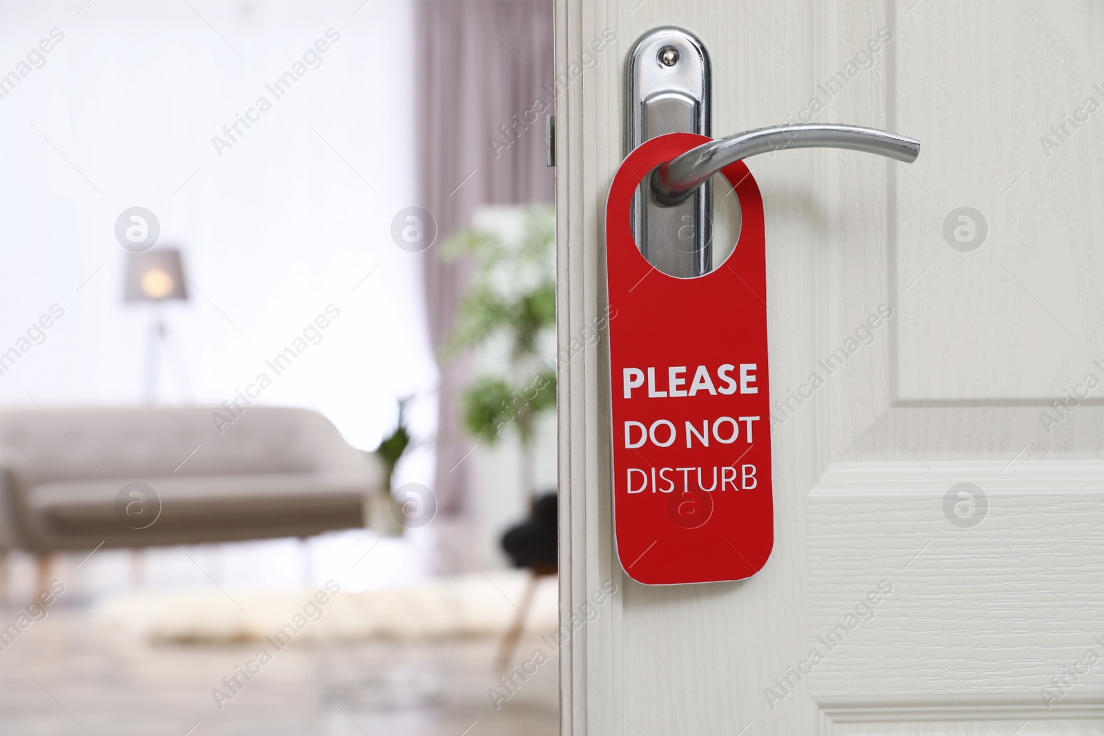 Photo of Open door with sign PLEASE DO NOT DISTURB on handle at hotel, space for text