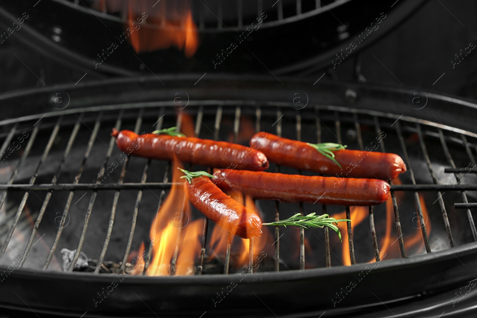 Photo of New modern barbecue grill with tasty sausages, closeup