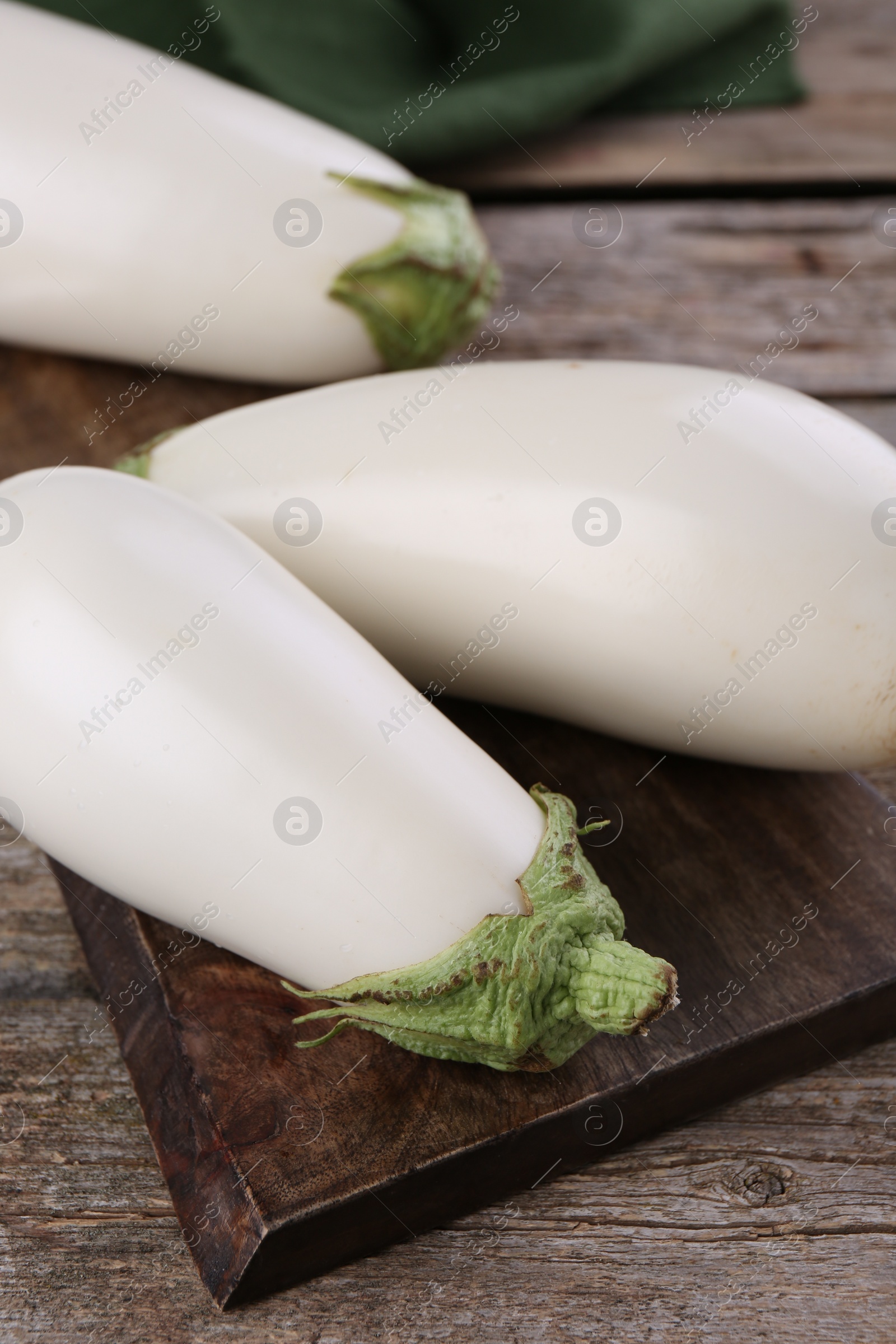 Photo of Three fresh white eggplants on wooden table