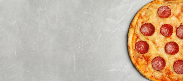 Image of Top view of hot delicious pizza on grey marble table, space for text. Banner design 