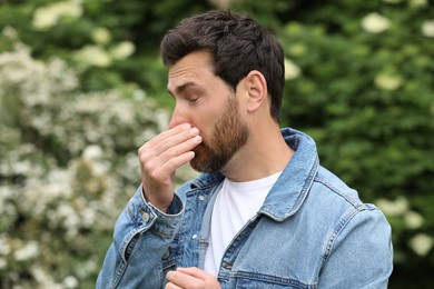 Man suffering from seasonal pollen allergy on spring day