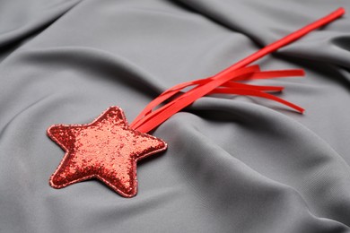 Photo of Beautiful red magic wand on grey fabric