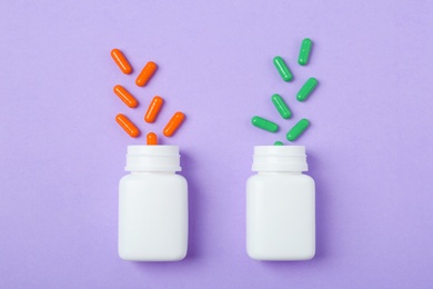 Photo of Bottles and different pills on color background, top view