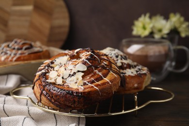 Photo of Delicious rolls with toppings and almond on wooden table, closeup. Sweet buns